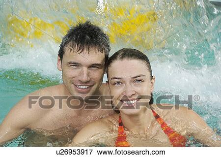 Stock Photo - Young couple in swimming pool portrait. Fotosearch
