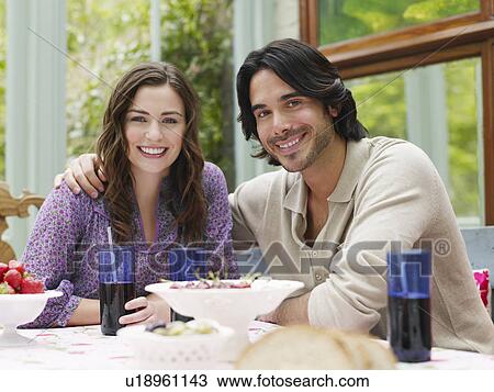 Young couple sitting at verandah table smiling portrait View Large Photo Image Stock Image - Young couple sitting at verandah table smiling portrait. Fotosearch