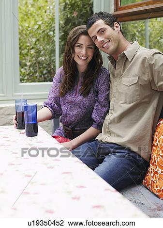 Young couple sitting at verandah table smiling portrait View Large Photo Image Stock Image - Young couple sitting at verandah table smiling portrait. Fotosearch