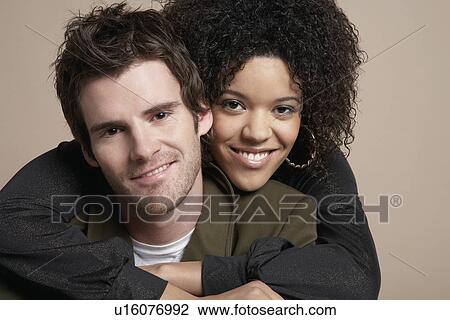 Young couple woman embracing man from behind portrait View Large Photo Image Stock Image - Young couple woman embracing man from behind portrait. Fotosearch