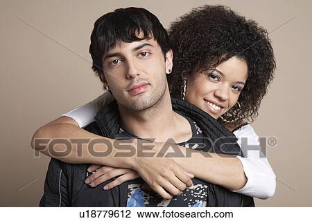 Young couple woman embracing man from behind portrait View Large Photo Image Stock Image - Young couple woman embracing man from behind portrait. Fotosearch