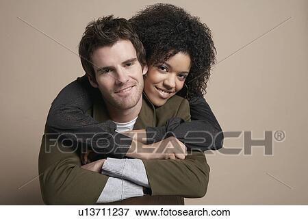 Young couple woman embracing man from behind portrait View Large Photo Image Stock Photo - Young couple woman embracing man from behind portrait. Fotosearch