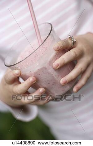 Young girl (5-6) holding glass with smoothie mid section View Large Photo Image Stock Image - Young girl (5-6) holding glass with smoothie mid section. Fotosearch
