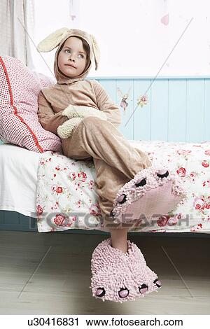Young girl (5-6) sitting on bed wearing bunny costume and monster slippers View Large Photo Image Stock Image - Young girl (5-6) sitting on bed wearing bunny costume and monster slippers. Fotosearch