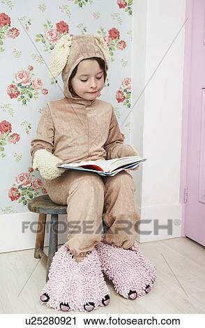 Young girl (5-6) sitting on stool reading wearing bunny costume and monster slippers View Large Photo Image Stock Image - Young girl (5-6) sitting on stool reading wearing bunny costume and monster slippers. Fotosearch