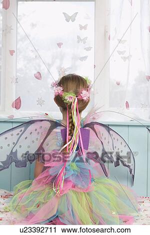 Young girl (5-6) wearing fairy costume looking through window back view View Large Photo Image Stock Image - Young girl (5-6) wearing fairy costume looking through window back view. Fotosearch