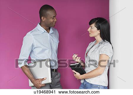 Young man and young woman talking by purple wall View Large Photo Image Stock Image - Young man and young woman talking by purple wall. Fotosearch