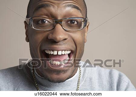 Young man laughing with mouth wide open close-up portrait View Large Photo Image Picture - Young man laughing with mouth wide open close-up portrait. Fotosearch