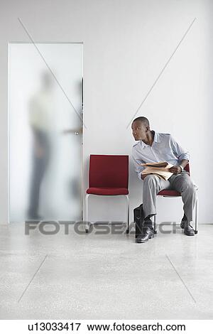 Young man listening to two people talking behind door View Large Photo Image Stock Photo - Young man listening to two people talking behind door. Fotosearch