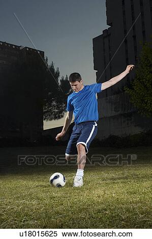 Young man playing football View Large Photo Image Stock Photography - Young man playing football. Fotosearch