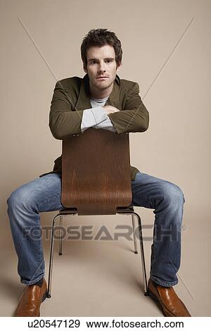 Young man sitting on chair portrait View Large Photo Image Stock Photo - Young man sitting on chair portrait. Fotosearch