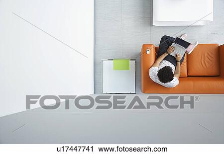 Young man using laptop in reception room view from above View Large Photo Image Stock Image - Young man using laptop in reception room view from above. Fotosearch