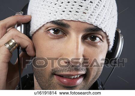 Young man wearing cap and headphones portrait close-up View Large Photo Image Picture - Young man wearing cap and headphones portrait close-up. Fotosearch