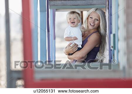 Young mother holding son (1-2) on outdoor porch portrait View Large Photo Image Stock Image - Young mother holding son (1-2) on outdoor porch portrait. Fotosearch