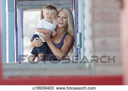 Young mother holding son (1-2) on outdoor porch portrait View Large Photo Image Stock Image - Young mother holding son (1-2) on outdoor porch portrait. Fotosearch