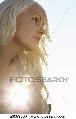 Young woman against sun close up low angle view View Large Photo Image Picture - Young woman against sun close up low angle view. Fotosearch