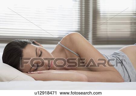 Young woman asleep in bed View Large Photo Image Stock Image - Young woman asleep in bed. Fotosearch