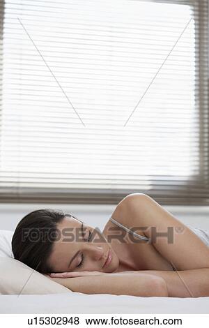Young woman asleep in bed View Large Photo Image Stock Photo - Young woman asleep in bed. Fotosearch