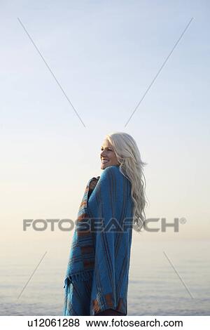 Young woman covered with blanket on beach portrait View Large Photo Image Stock Photo - Young woman covered with blanket on beach portrait. Fotosearch