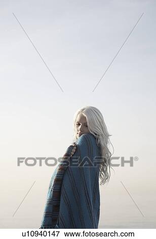 Young woman covered with blanket against sky View Large Photo Image Stock Photo - Young woman covered with blanket against sky. Fotosearch