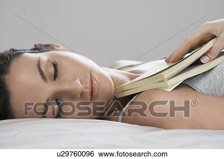 Young woman holding book asleep on bed close-up View Large Photo Image Stock Photograph - Young woman holding book asleep on bed close-up. Fotosearch