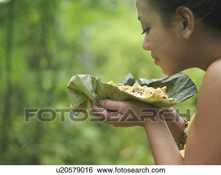 Young woman holding food on leaf smelling it View Large Photo Image Stock Photograph - Young woman holding food on leaf smelling it. Fotosearch