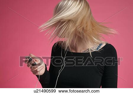 Young woman holding mp3 player and tossing hair View Large Photo Image Stock Photo - Young woman holding mp3 player and tossing hair. Fotosearch