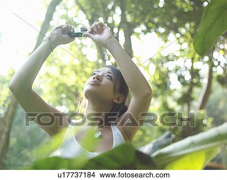 Young woman in forest taking photograph arms raised View Large Photo Image Picture - Young woman in forest taking photograph arms raised. Fotosearch