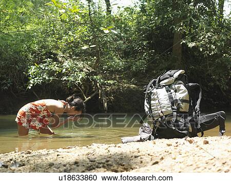 Young woman in lake drinking water backpack on shore View Large Photo Image Stock Image - Young woman in lake drinking water backpack on shore. Fotosearch