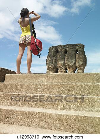 Young woman looking at ancient ruins back view View Large Photo Image Stock Image - Young woman looking at ancient ruins back view. Fotosearch