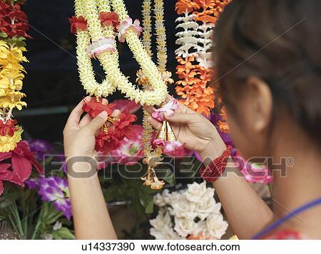 Young woman looking at artificial flowers necklaces back view selective focus View Large Photo Image Stock Image - Young woman looking at artificial flowers necklaces back view selective focus. Fotosearch