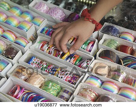 Young woman looking at different bracelettes on display close-up on hand View Large Photo Image Stock Photo - Young woman looking at different bracelettes on display close-up on hand. Fotosearch