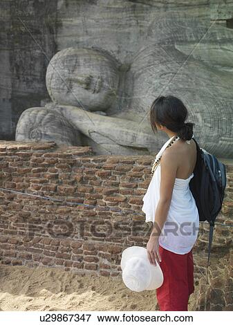 Young woman looking at statue of sleeping Buddha side view View Large Photo Image Stock Photo - Young woman looking at statue of sleeping Buddha side view. Fotosearch