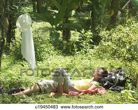Young woman lying in tropical forest sunbathing View Large Photo Image Stock Image - Young woman lying in tropical forest sunbathing. Fotosearch