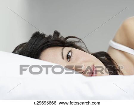 Young woman lying on bed close-up View Large Photo Image Stock Photograph - Young woman lying on bed close-up. Fotosearch