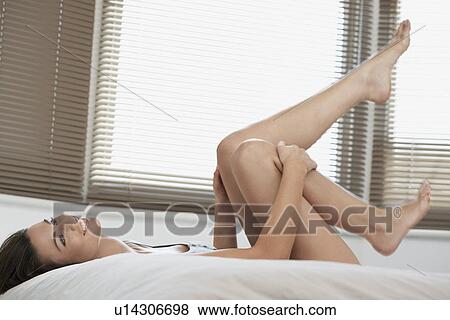 Young woman lying on bed looking up View Large Photo Image Stock Photo - Young woman lying on bed looking up. Fotosearch