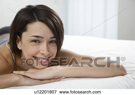 Young woman lying on bed portrait View Large Photo Image Stock Photo - Young woman lying on bed portrait. Fotosearch