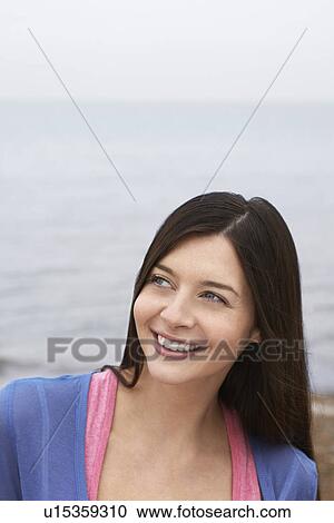 Stock Image - Young woman on beach smiling. Fotosearch