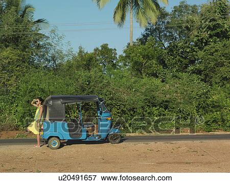 Young woman on dirt road leaning on old fashioned motor scooter side view View Large Photo Image Stock Photo - Young woman on dirt road leaning on old fashioned motor scooter side view. Fotosearch