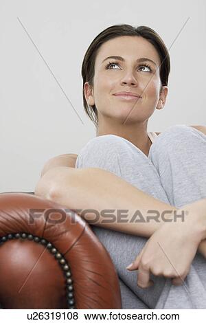 Young woman relaxing on sofa looking up View Large Photo Image Stock Photo - Young woman relaxing on sofa looking up. Fotosearch
