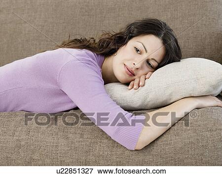 Stock Photo - Young woman relaxing on sofa. Fotosearch