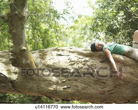 Young woman resting on rock formation in forest side view View Large Photo Image Stock Image - Young woman resting on rock formation in forest side view. Fotosearch