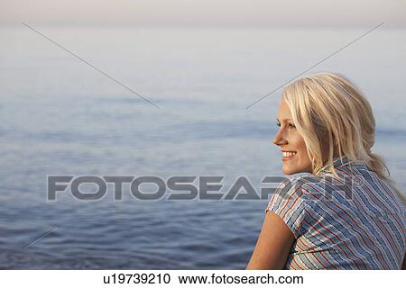 Young woman sitting on beach side view View Large Photo Image Stock Image - Young woman sitting on beach side view. Fotosearch