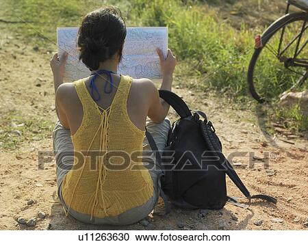 Young woman sitting on dirt road reading mapback view View Large Photo Image Stock Image - Young woman sitting on dirt road reading mapback view. Fotosearch