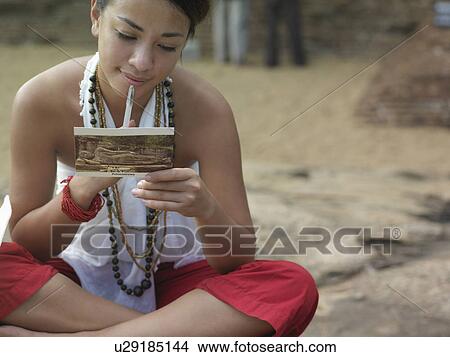 Young woman sitting on rock reading postcard mid section View Large Photo Image Picture - Young woman sitting on rock reading postcard mid section. Fotosearch