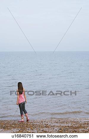 Young woman standing on beach back view View Large Photo Image Stock Image - Young woman standing on beach back view. Fotosearch
