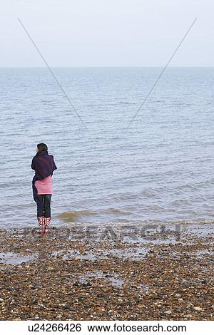 Young woman standing on beach back view View Large Photo Image Stock Photograph - Young woman standing on beach back view. Fotosearch