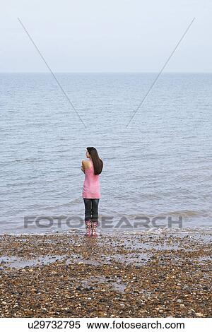 Young woman standing on beach back view View Large Photo Image Stock Photography - Young woman standing on beach back view. Fotosearch