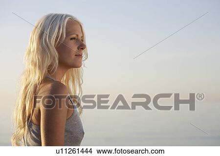 Young woman standing on beach side view View Large Photo Image Picture - Young woman standing on beach side view. Fotosearch