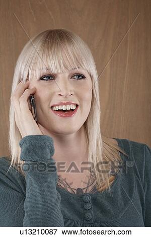 Young woman talking on mobile phone and smiling View Large Photo Image Stock Photo - Young woman talking on mobile phone and smiling. Fotosearch